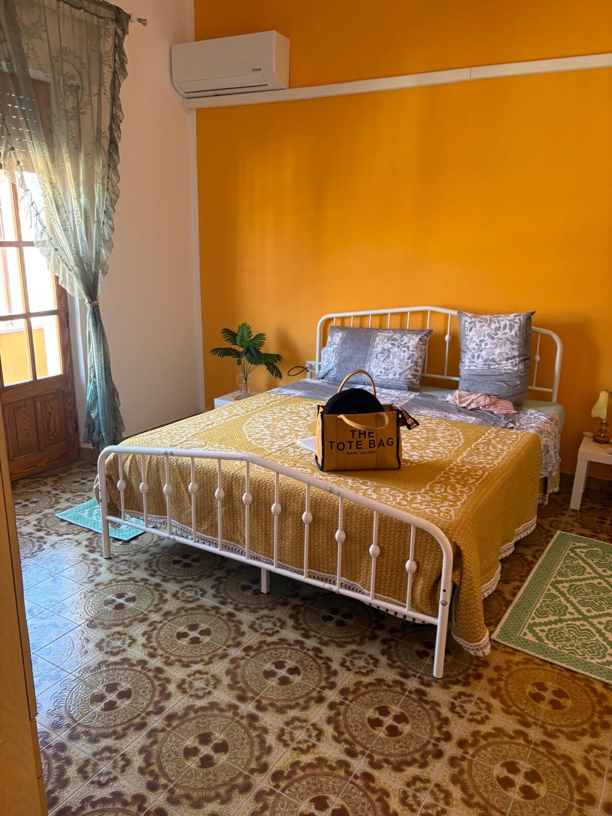 Schlafzimmer mit sonnengelber Wand und Balkon